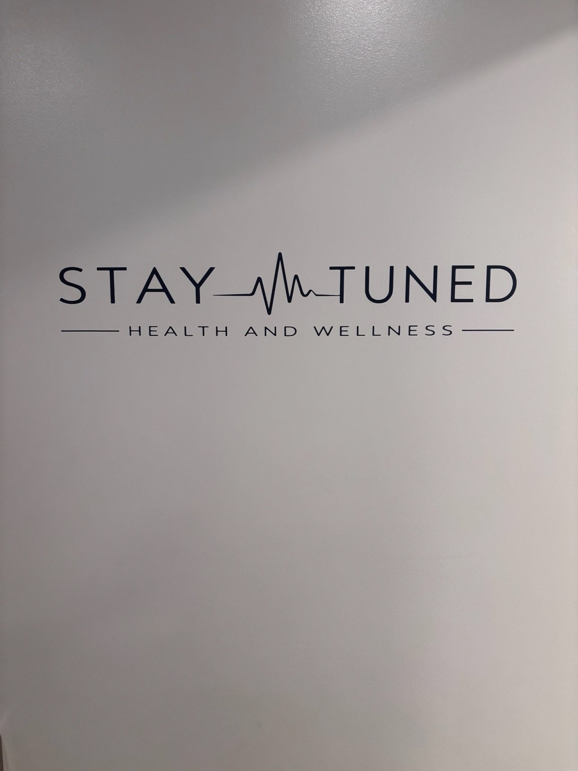 Stay Tuned Health and Wellness logo on wall